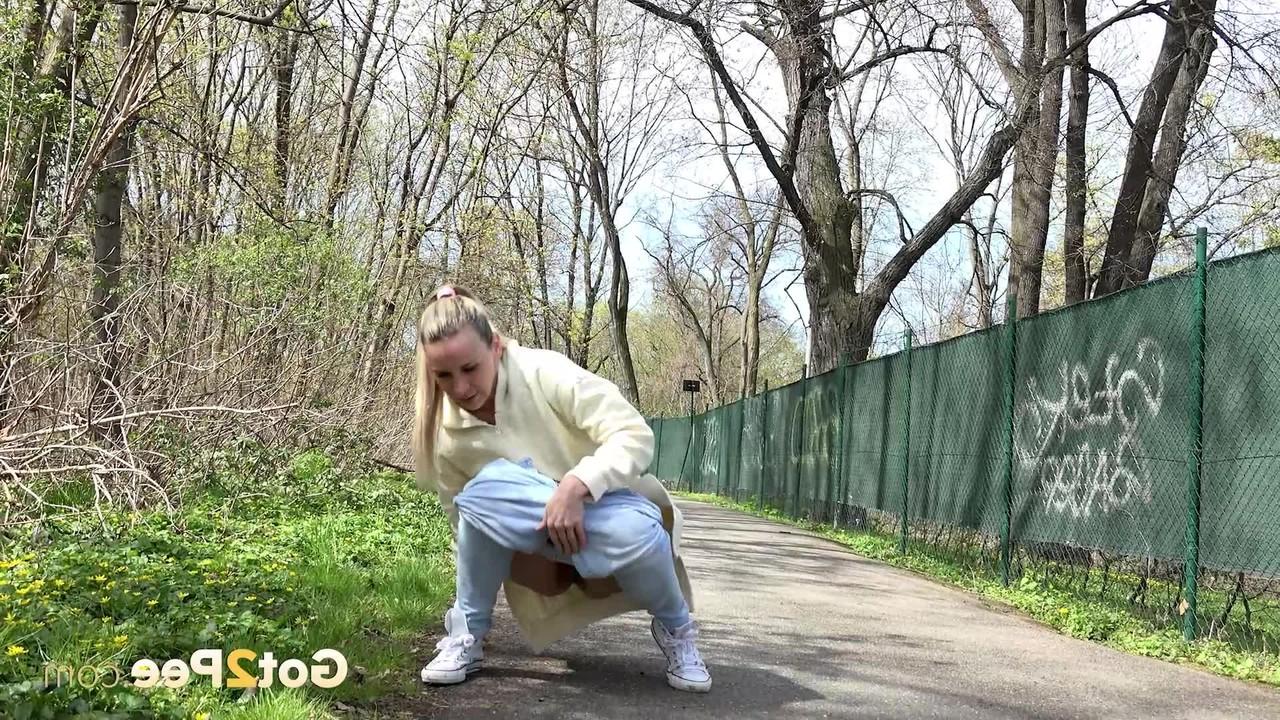 15P La rubia Bianca se baja los pantalones deportivos para orinar en un sendero pavimentado