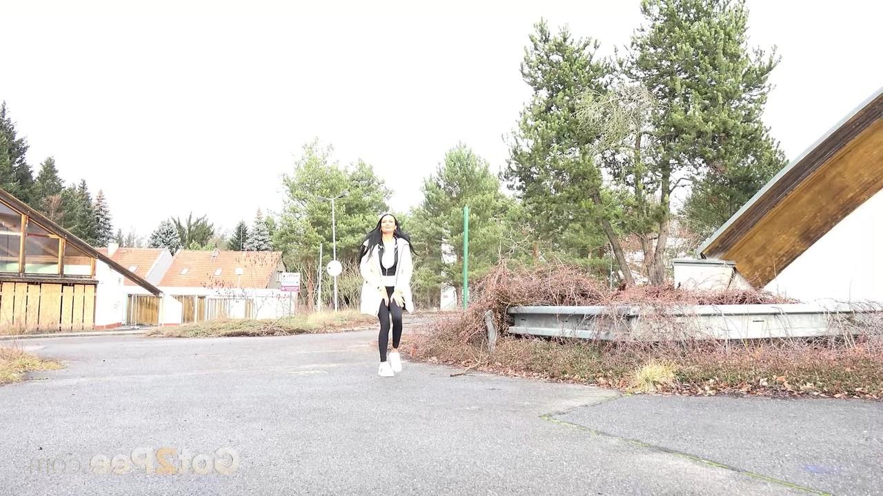 15P Das dunkelhaarige Mädchen Maddi Black hockt neben einem Auto, um zu pinkeln