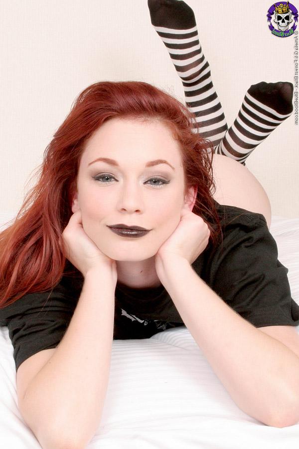 15P Justine Joli, rousse pâle, se doigte la chatte tout en portant des hauts de cuisse rayés.