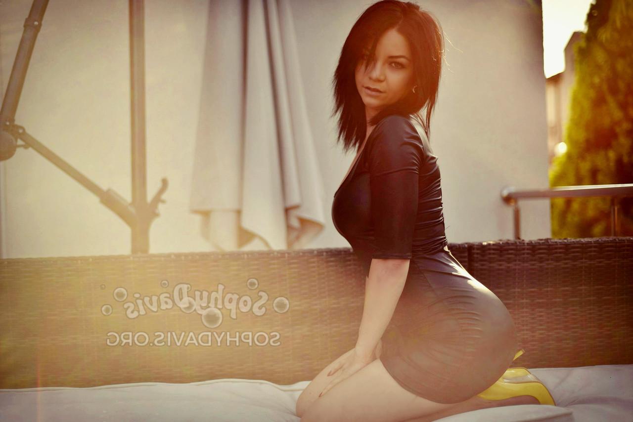 15P La chaude brune Sophy Davis pose dans sa robe moulante sexy et ses talons en solo.
