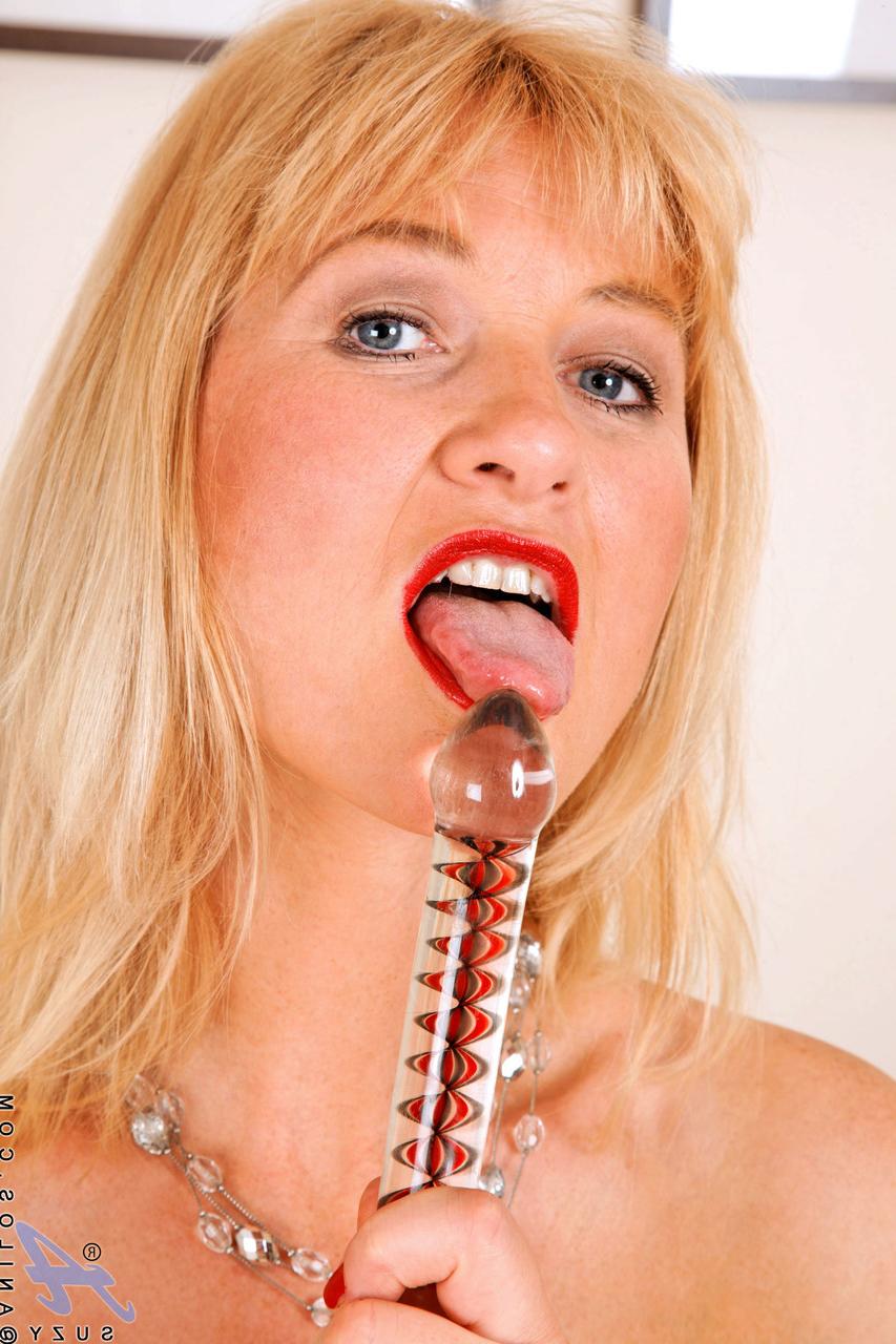20P Suzy, blonde mature, glisse un jouet en verre dans sa délicieuse chatte.