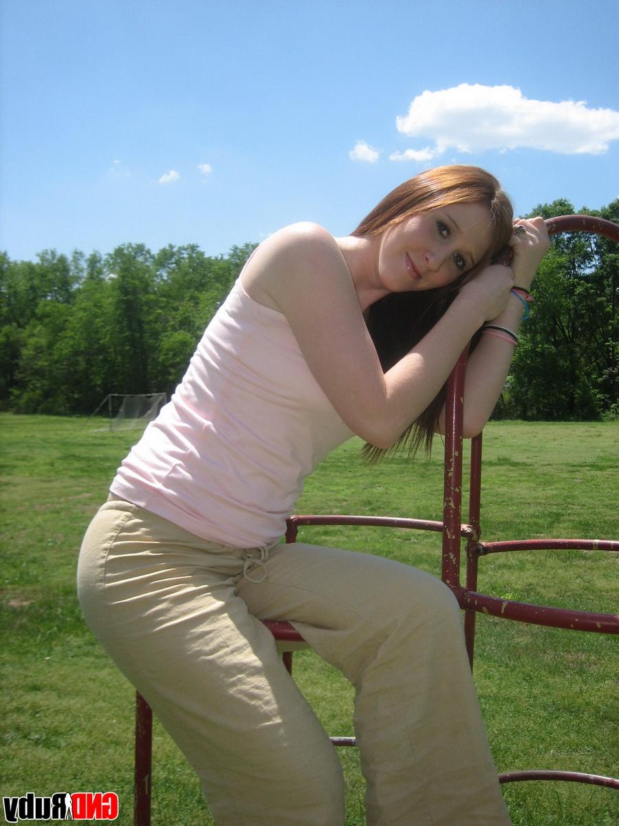 12P Natural redhead flashes her tits on playground equipment in a field