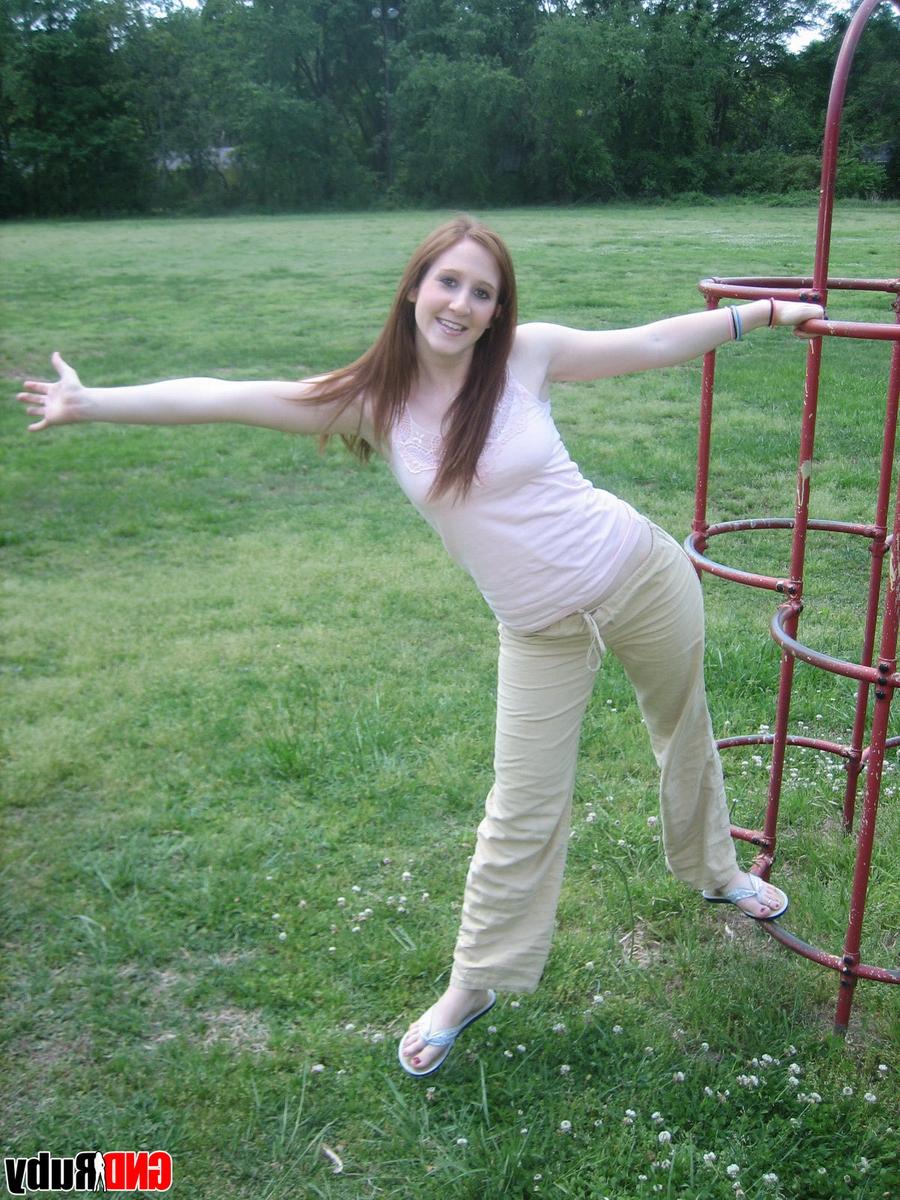 12P Natural redhead flashes her tits on playground equipment in a field