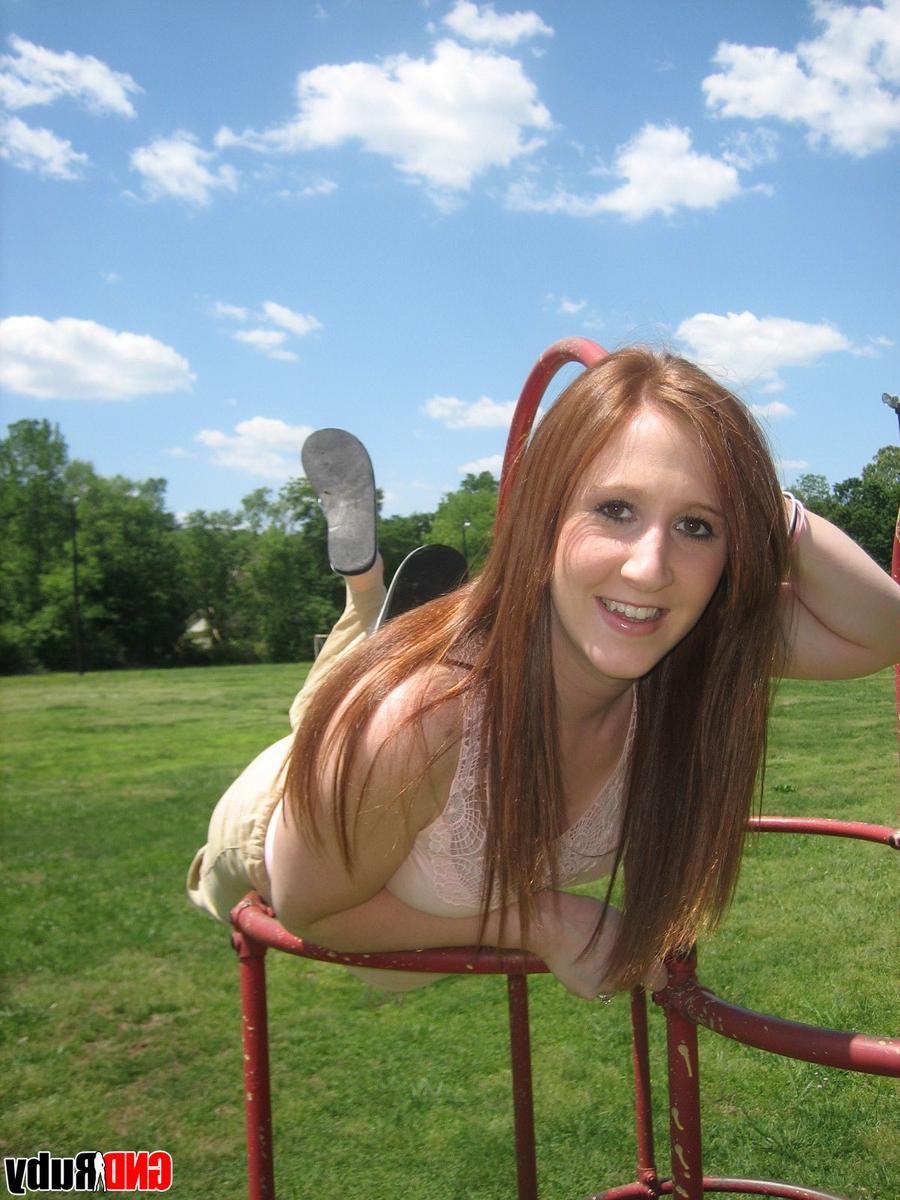 12P Natural redhead flashes her tits on playground equipment in a field