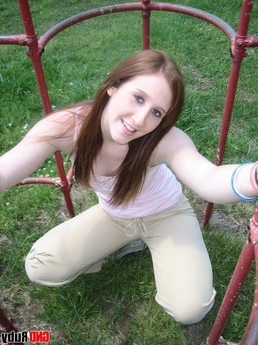 12P Natural redhead flashes her tits on playground equipment in a field