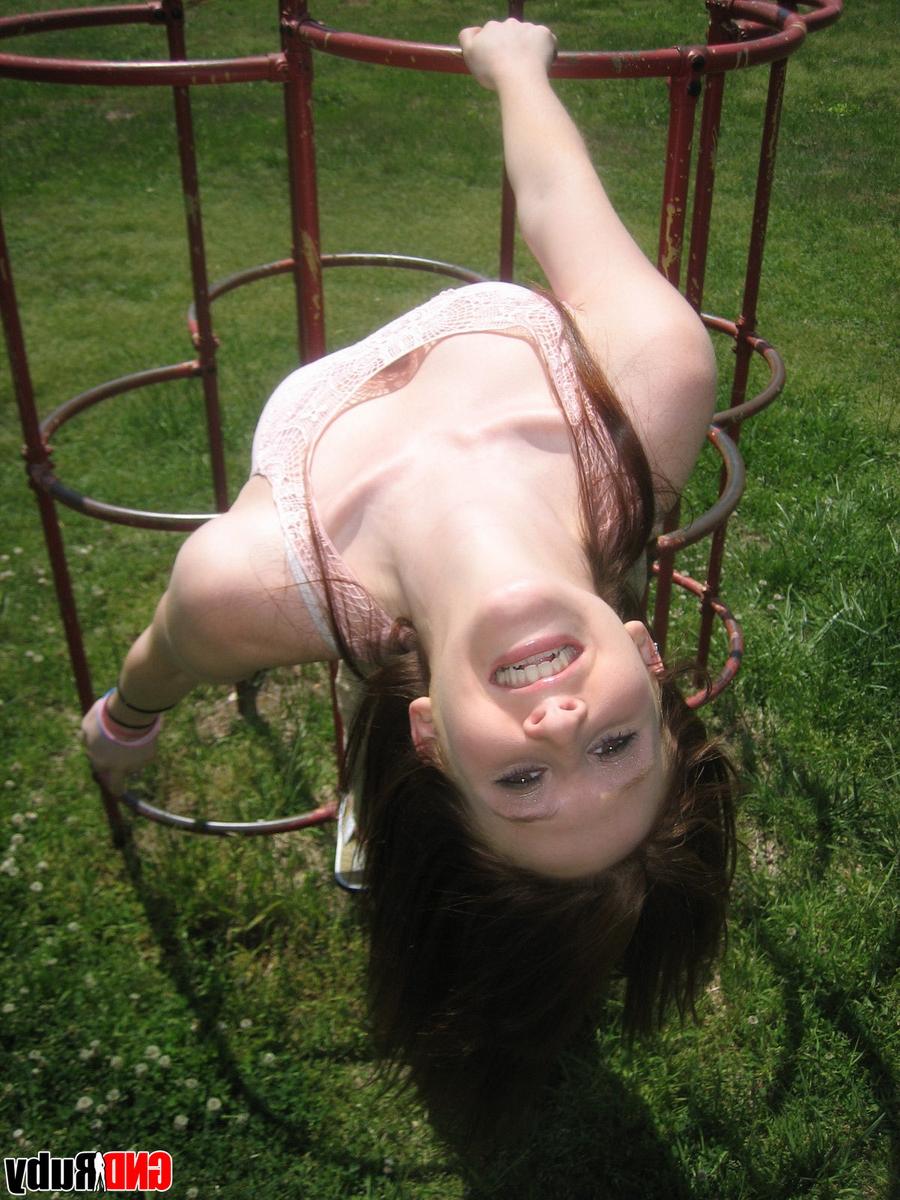 12P Natural redhead flashes her tits on playground equipment in a field