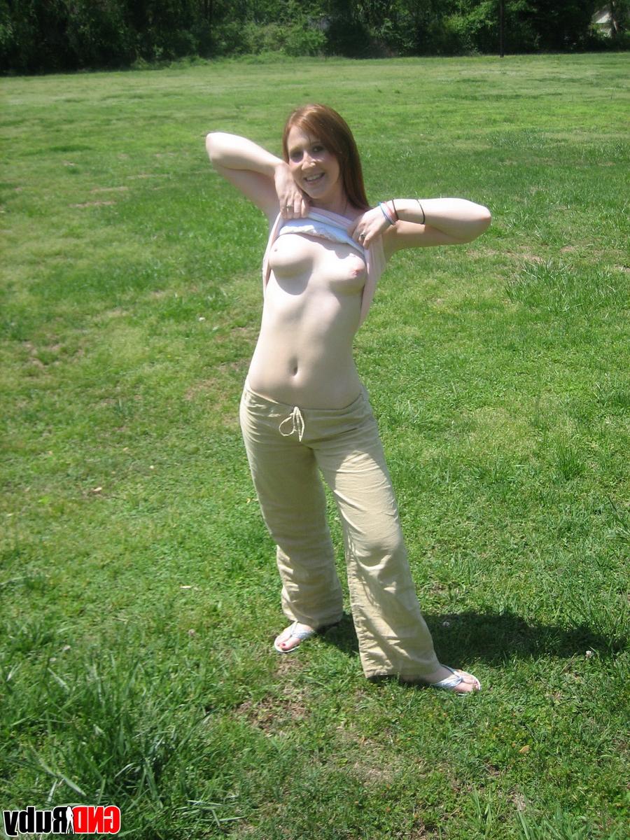 12P Natural redhead flashes her tits on playground equipment in a field