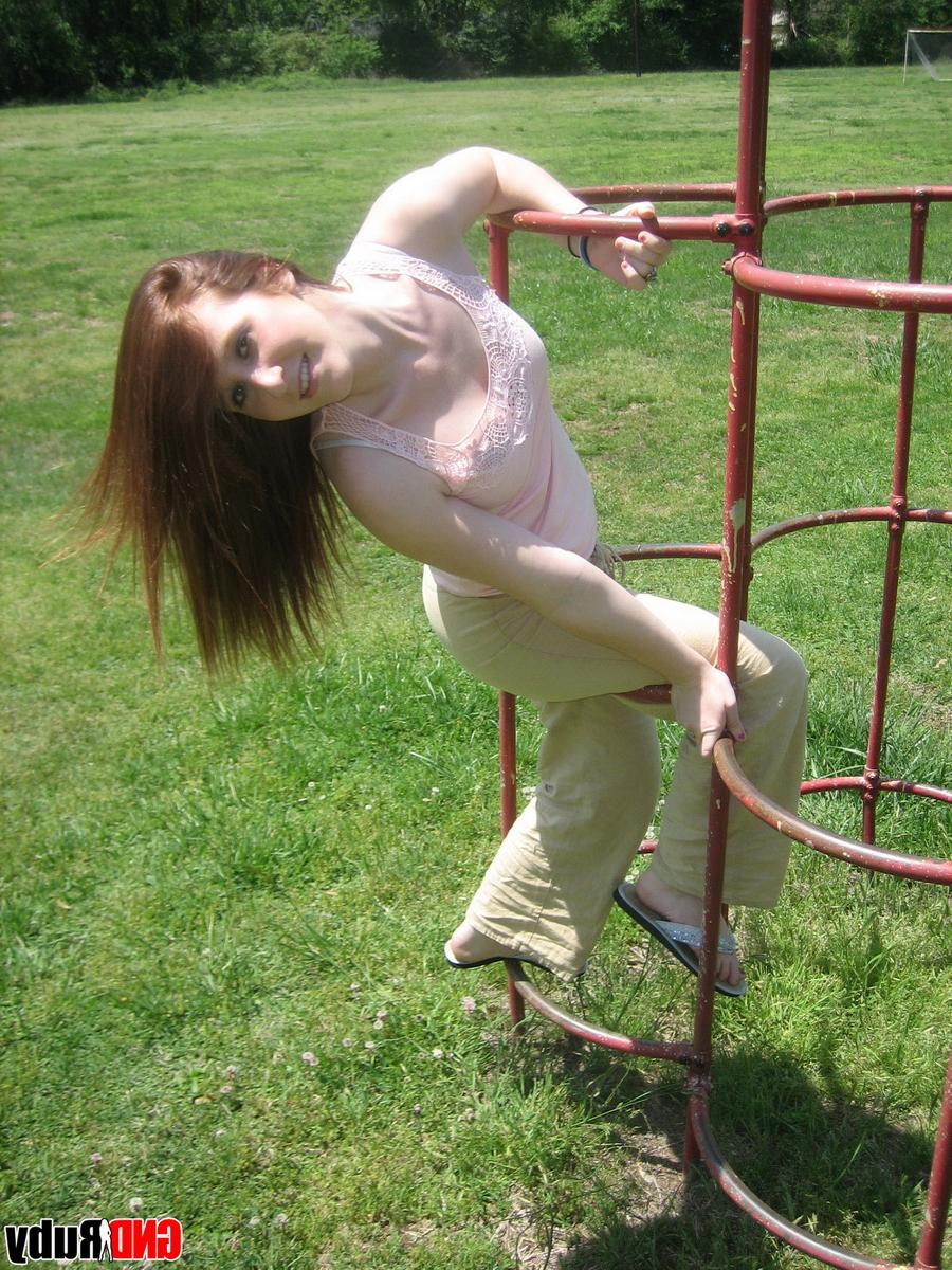 12P Natural redhead flashes her tits on playground equipment in a field