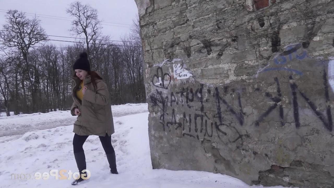 15P A garota baixinha Katya Red se abaixa entre dois prédios para fazer xixi na neve