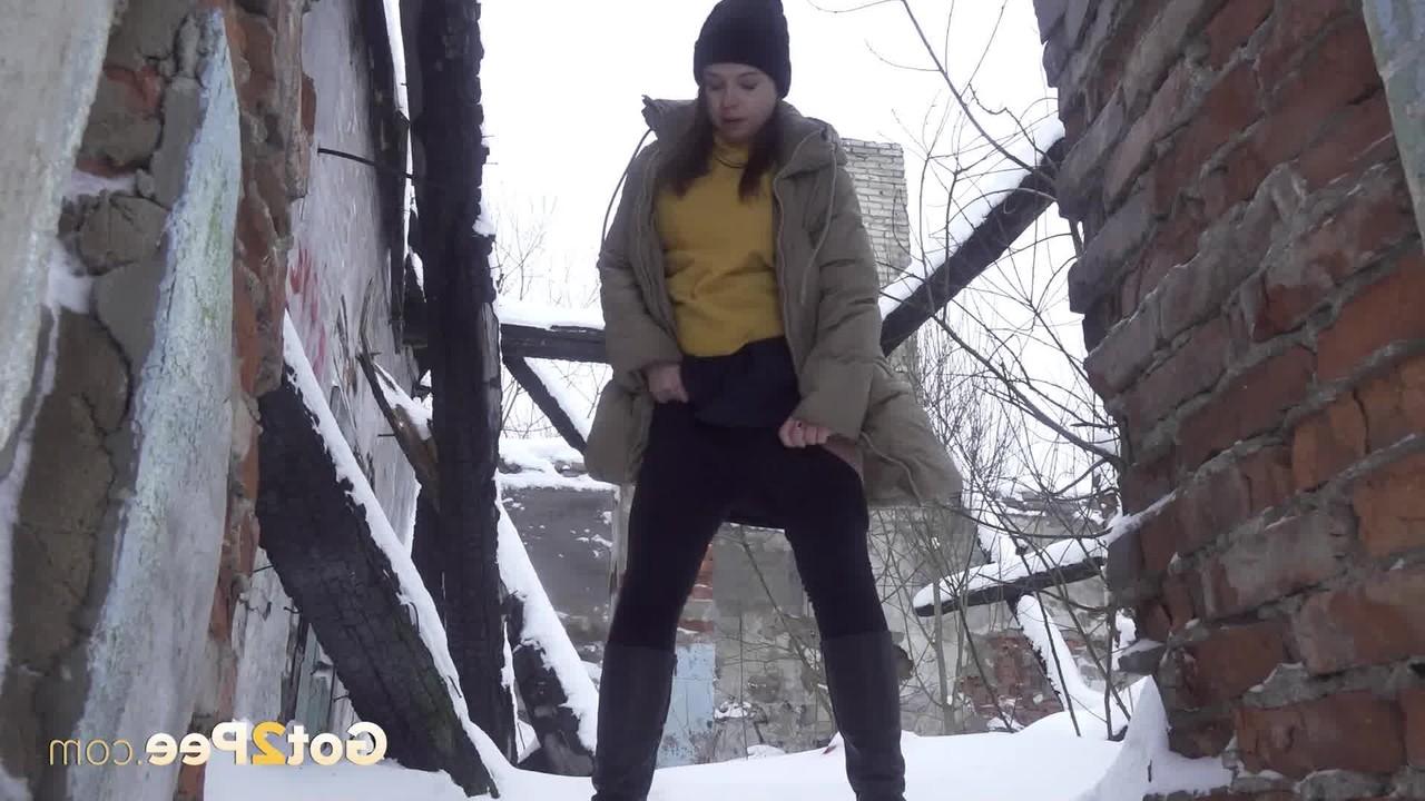 15P A garota baixinha Katya Red se abaixa entre dois prédios para fazer xixi na neve