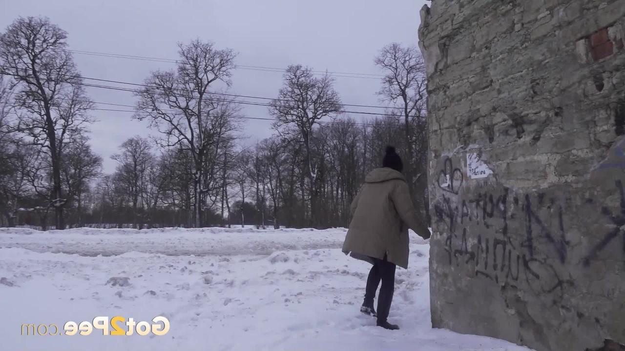 15P A garota baixinha Katya Red se abaixa entre dois prédios para fazer xixi na neve