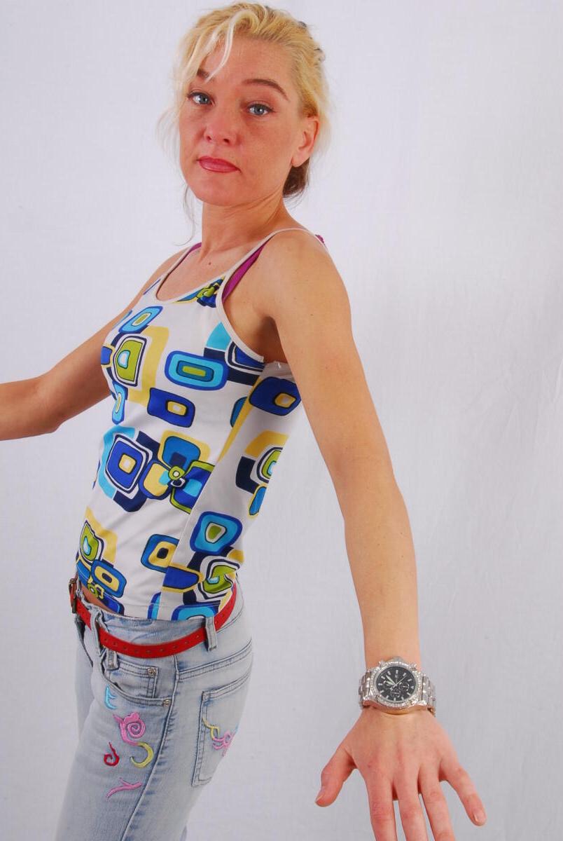 16P Lilly, la rubia de ojos azules, modela un enorme reloj de metal durante una acción segura para el trabajo