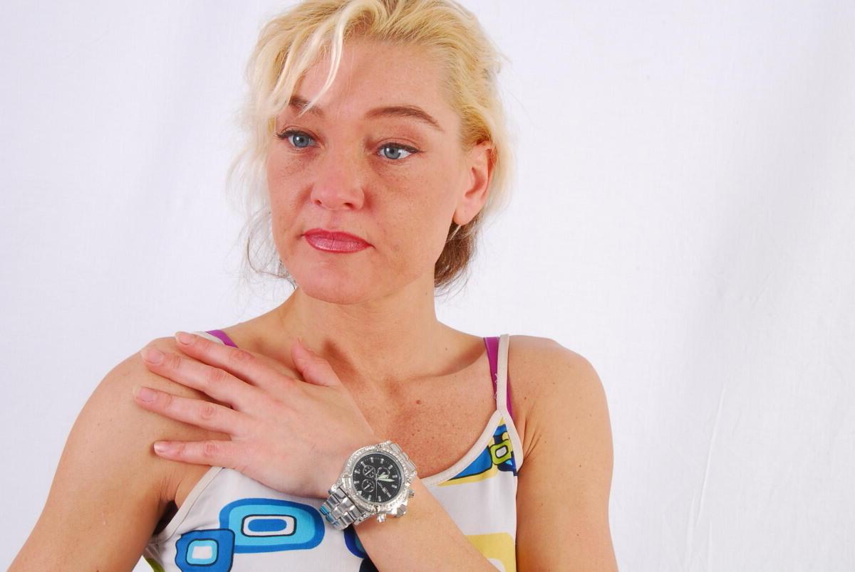 16P Lilly, la rubia de ojos azules, modela un enorme reloj de metal durante una acción segura para el trabajo