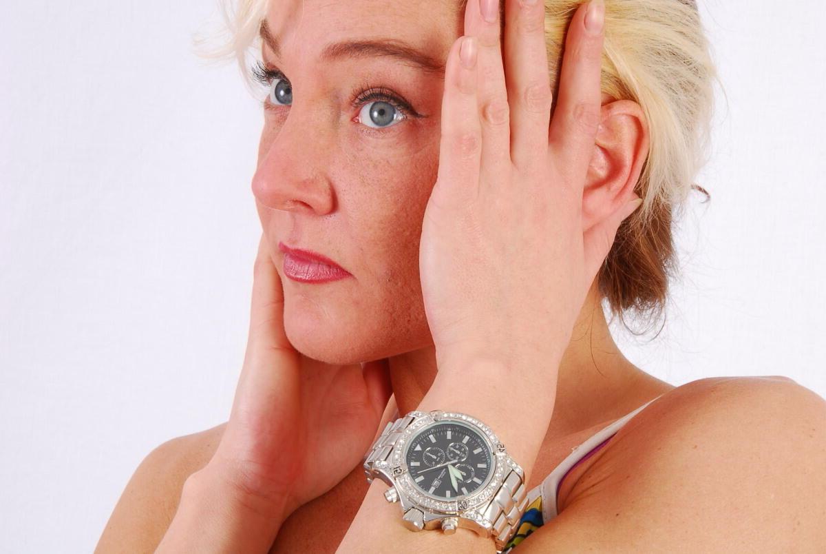 16P Lilly, la rubia de ojos azules, modela un enorme reloj de metal durante una acción segura para el trabajo