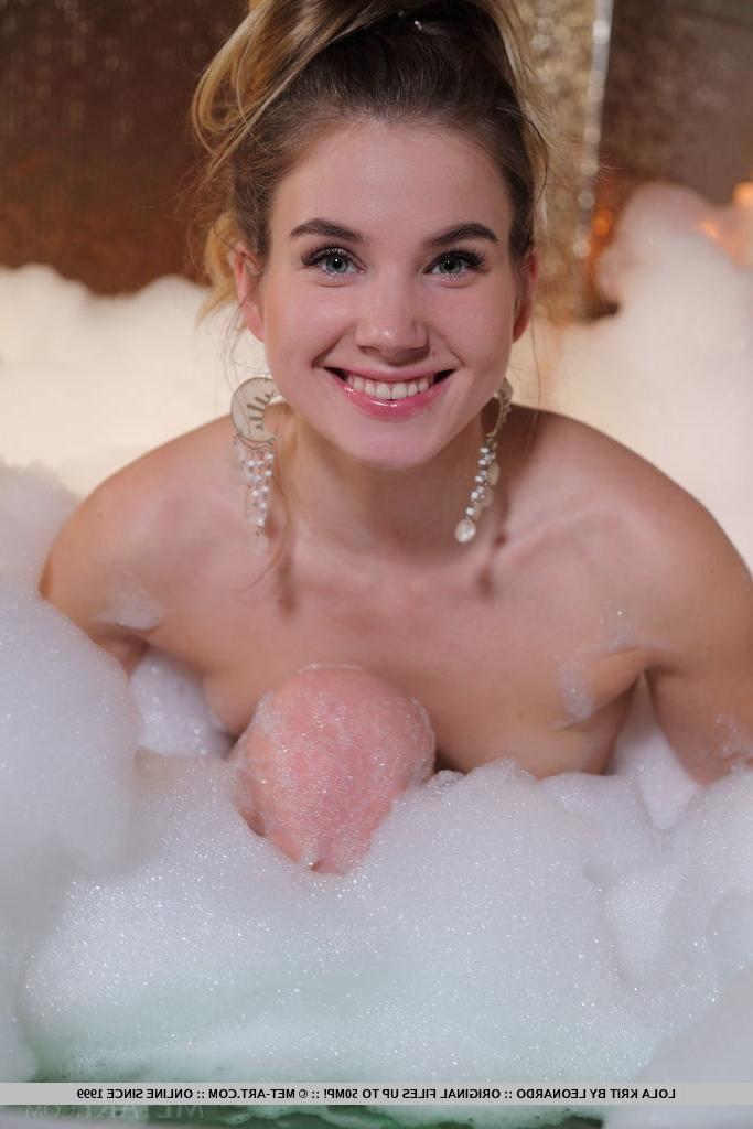 18P A bela adolescente Lola Krit usa o cabelo preso com brincos enquanto toma banho de espuma