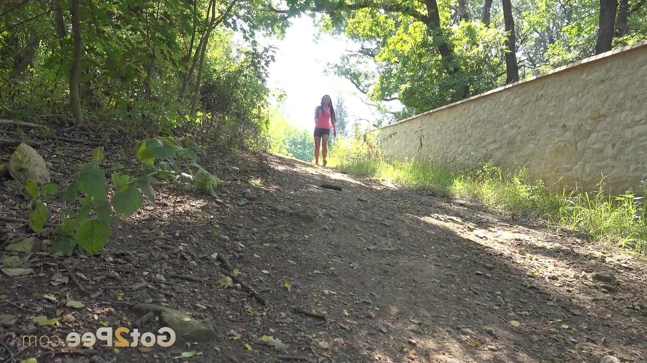 15P Dafne, une fille célibataire, fait pipi par terre derrière une clôture pendant la journée.