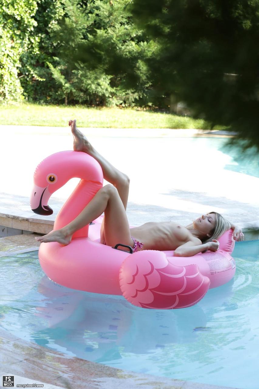 10P La sexy Gina Gerson se quita la parte superior del bikini mientras posa en un flotador de flamencos en la piscina
