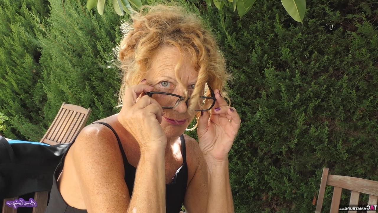16P La rubia mayor Anne Swinger se masturba en una silla del patio