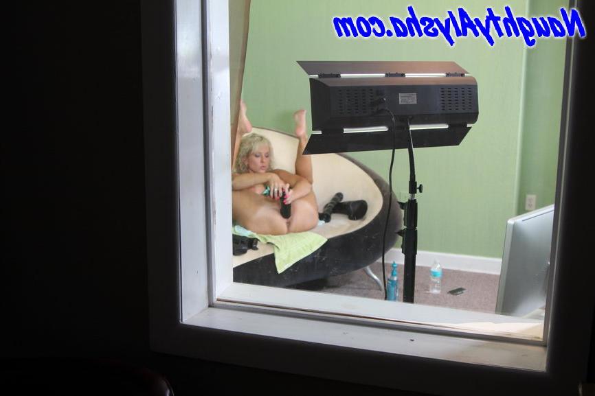 15P Blondes Mädchen führt während einer Camshow gleichzeitig ein paar riesige Dildos ein
