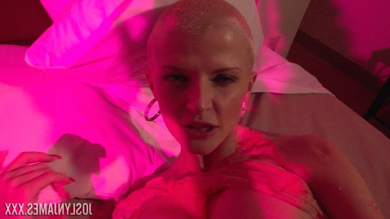 14P Joslyn James, blonde d'âge moyen, montre ses gros seins et ses fesses sur un lit.