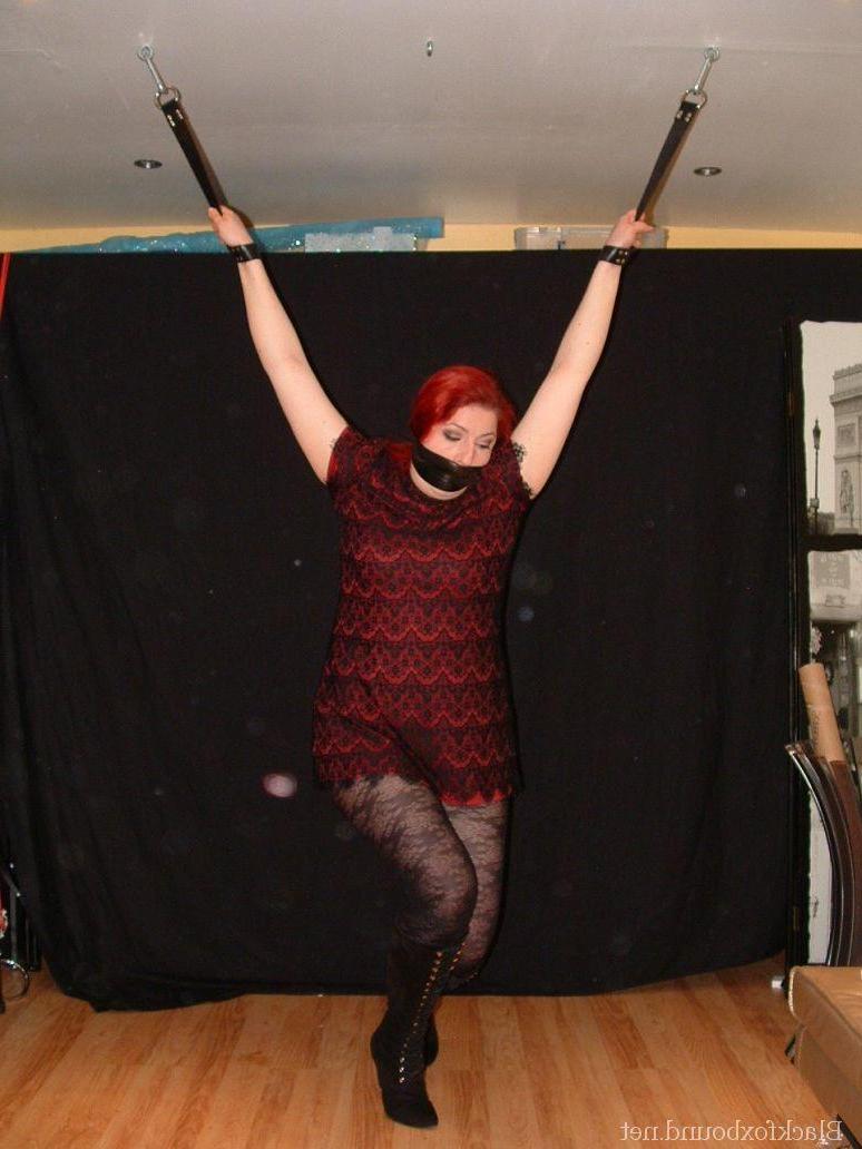 16P Pale redhead is silenced with a gag while restrained by her wrists in clothes