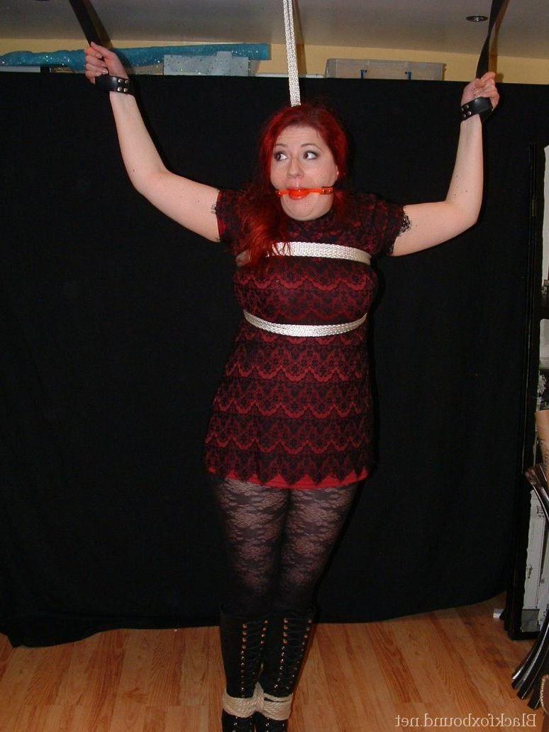 16P Pale redhead is silenced with a gag while restrained by her wrists in clothes