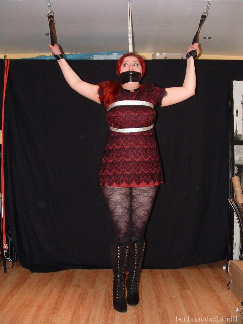 16P Pale redhead is silenced with a gag while restrained by her wrists in clothes
