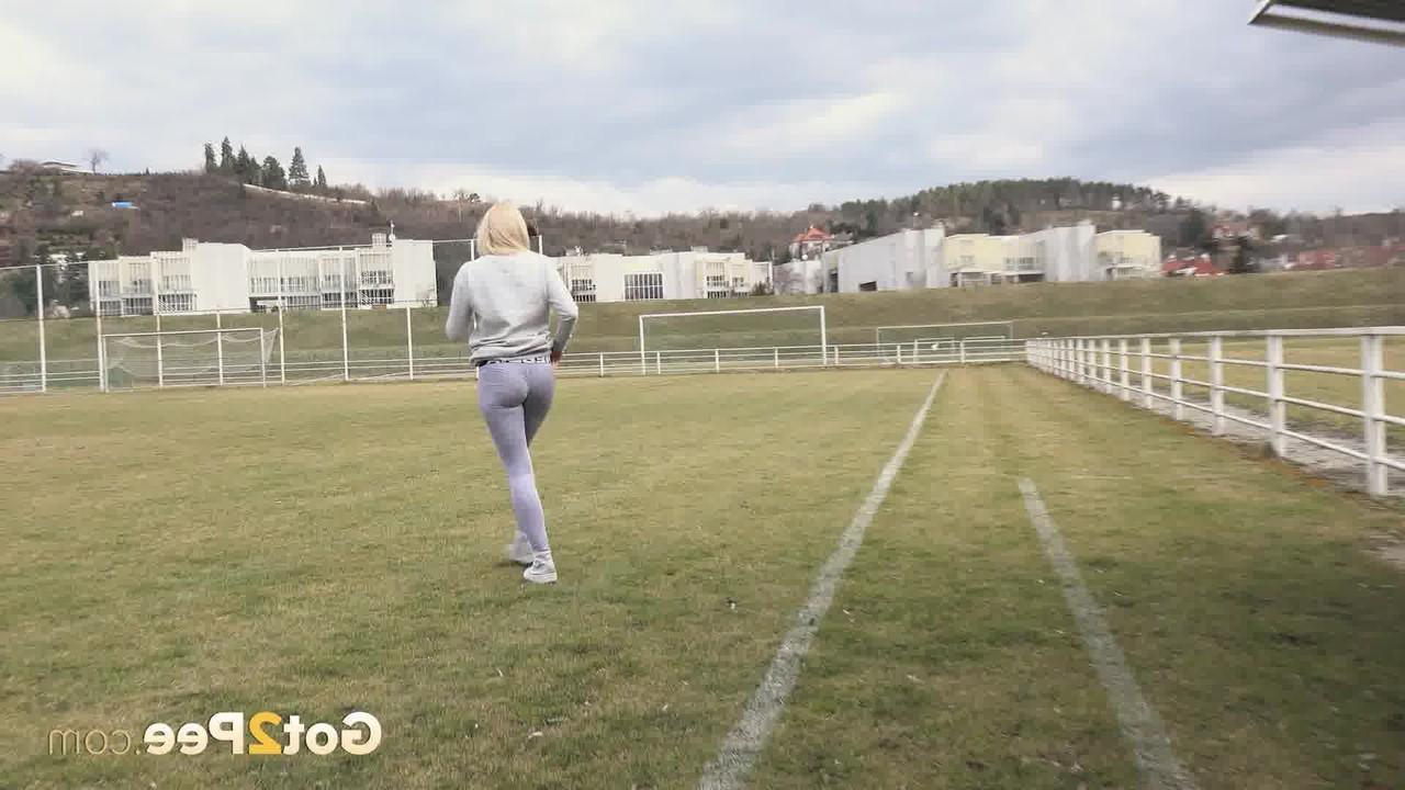15P La blonde Katy Sky baisse ses leggings avant de pisser sur un banc de football.