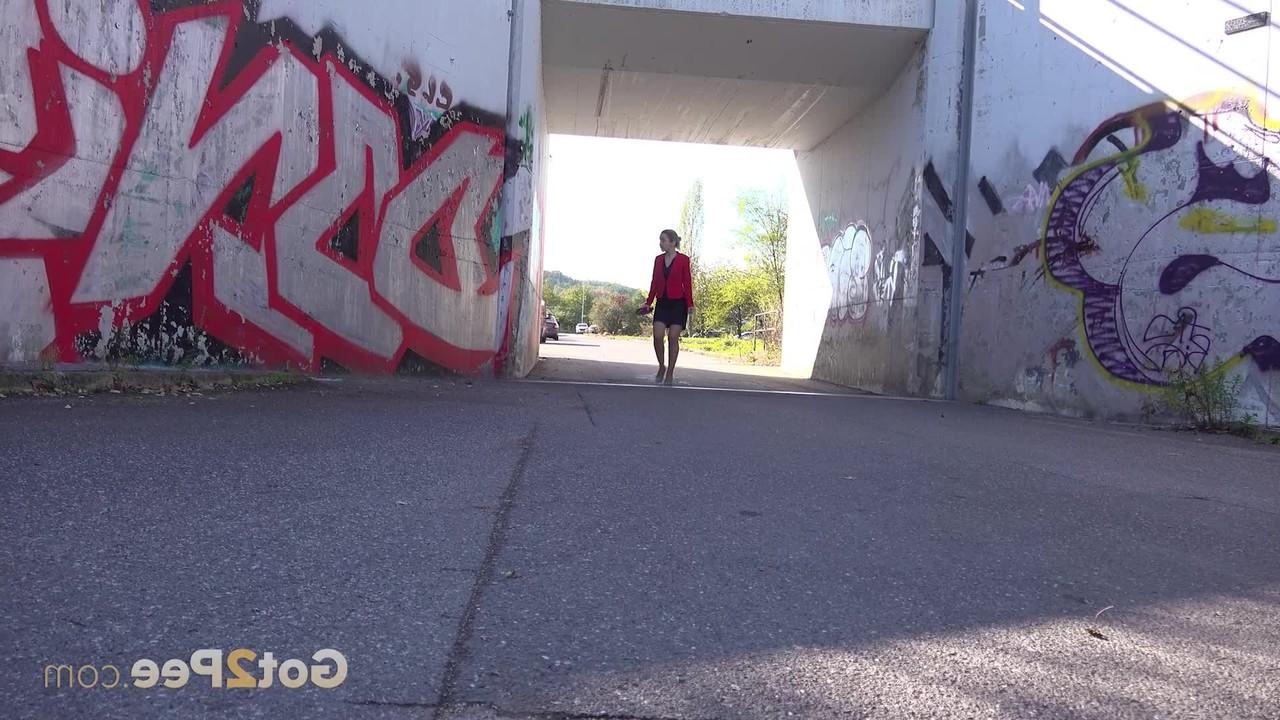 15P La blonde Di Devi pisse devant un mur couvert de graffitis