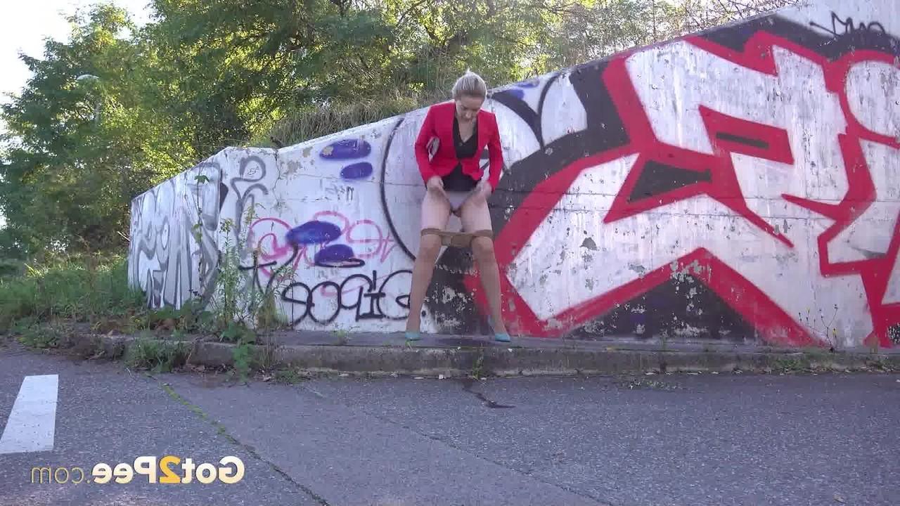 15P La blonde Di Devi pisse devant un mur couvert de graffitis