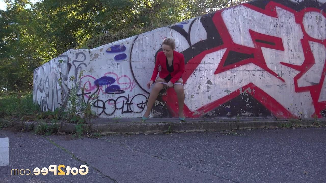 15P La blonde Di Devi pisse devant un mur couvert de graffitis