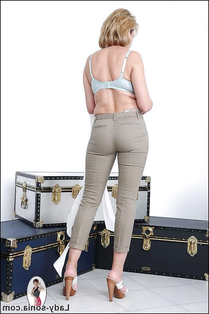 15P Rubia madura de piernas largas con grandes latas redondas quitándose lentamente la ropa
