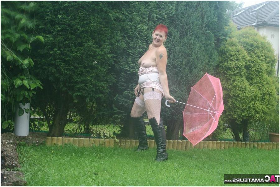 20P 年配の赤毛のヴァルガスミック露出モデルがブロリーを持ちながら雨の中でヌード