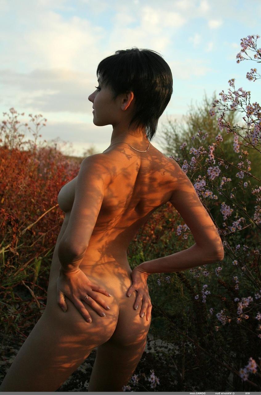 20P Kiti, une jeune femme aux cheveux courts, pose nue et s'excite avec son gros cul en extérieur.