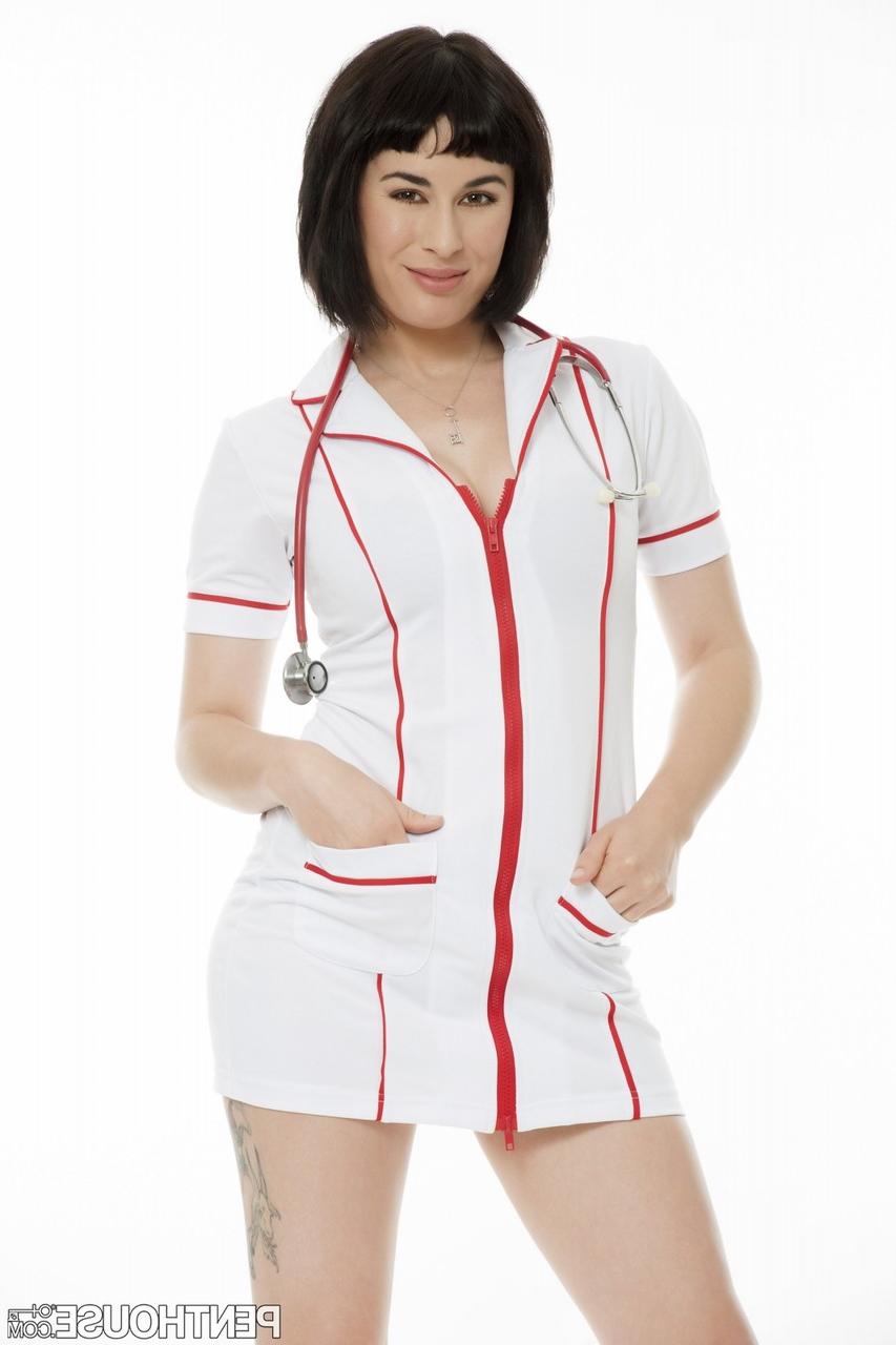 17P La superbe infirmière Olive Glass enlève lentement son uniforme et montre son corps sexy.