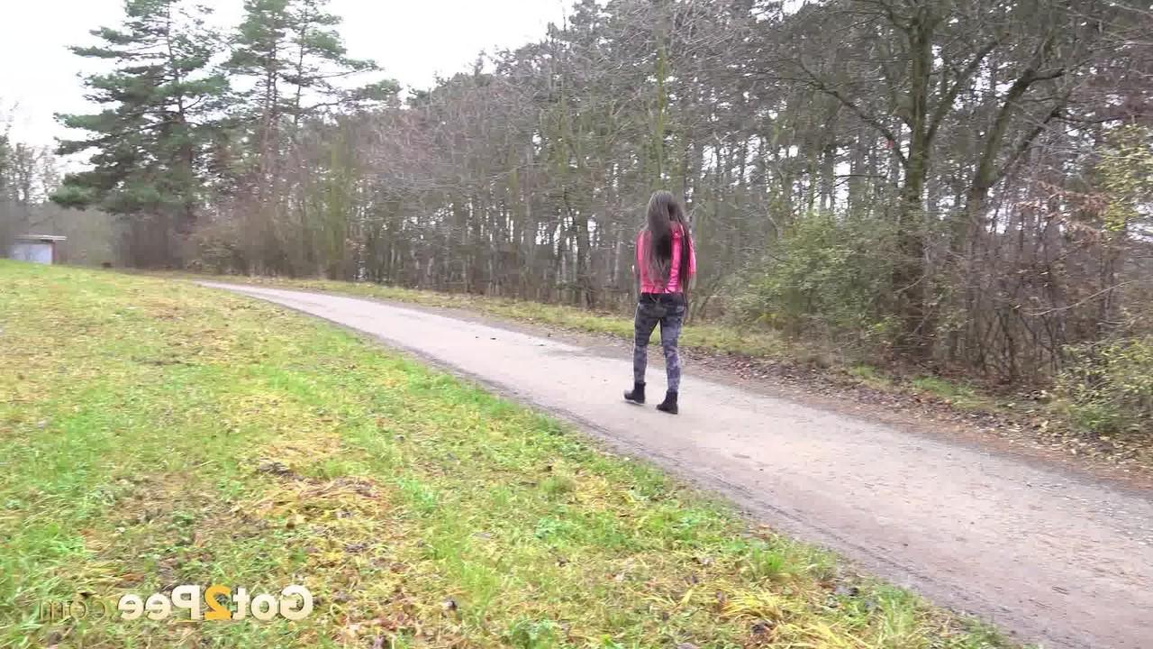15P Lara Fox, une fille blanche, baisse ses leggings pour faire pipi sur une route rurale.