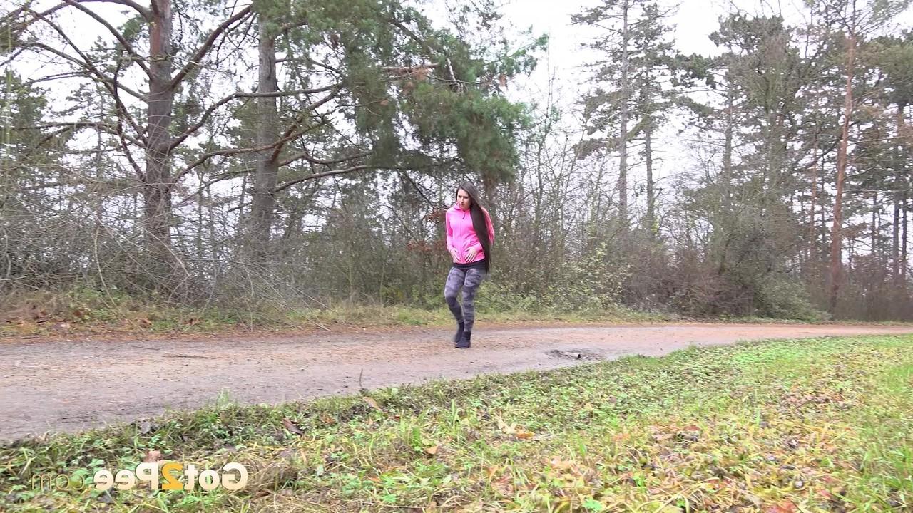 15P Lara Fox, une fille blanche, baisse ses leggings pour faire pipi sur une route rurale.