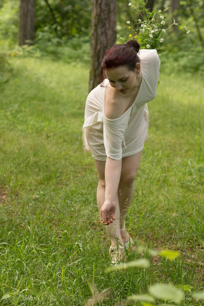 16P Lisa Musa, rousse et maigre, se déshabille près d'un étang.