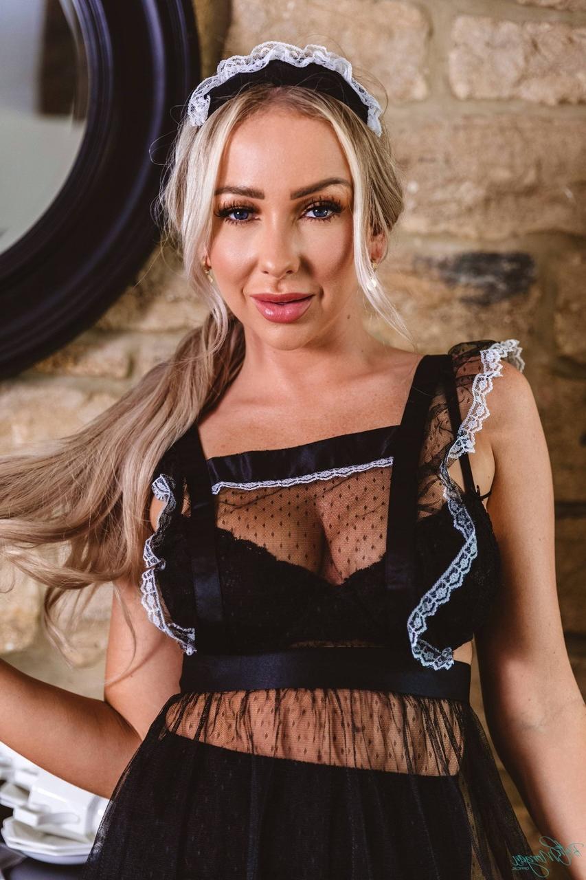12P La chaude blonde Beth Morgan libère ses superbes seins avec un porte-jarretelles et des bas nylons foncés.