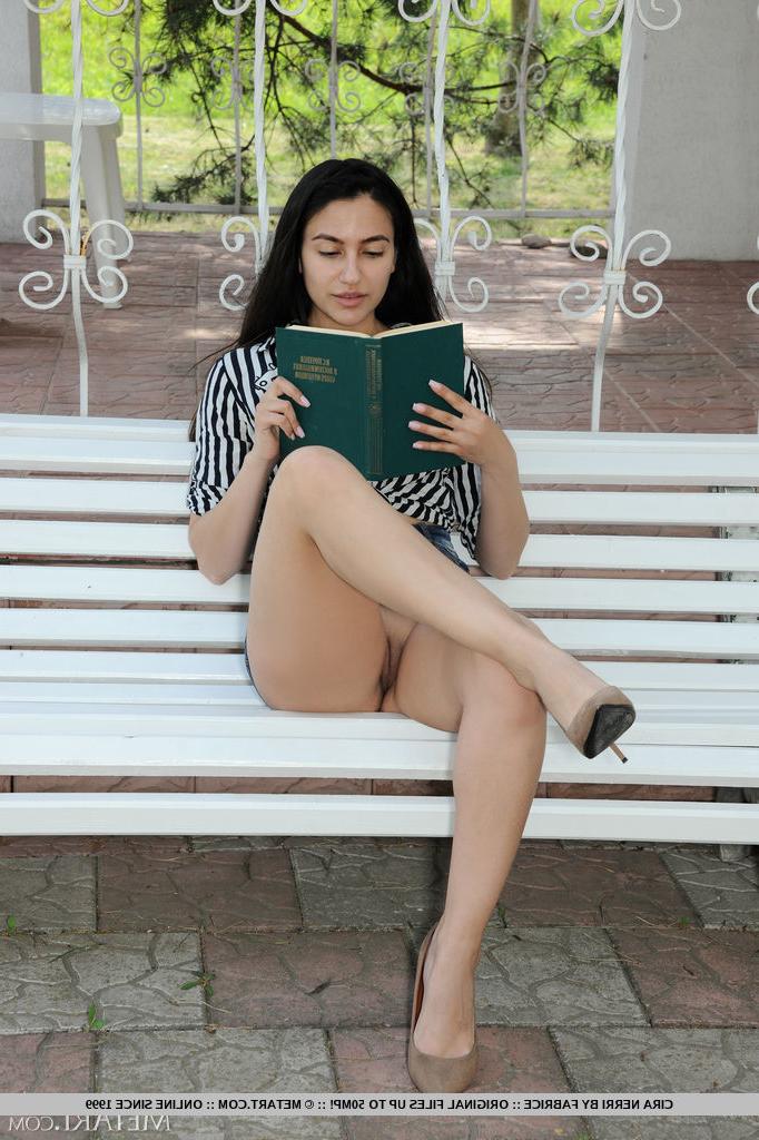 18P A adolescente morena Cira Nerri fica nua enquanto lê um livro em um banco ao ar livre