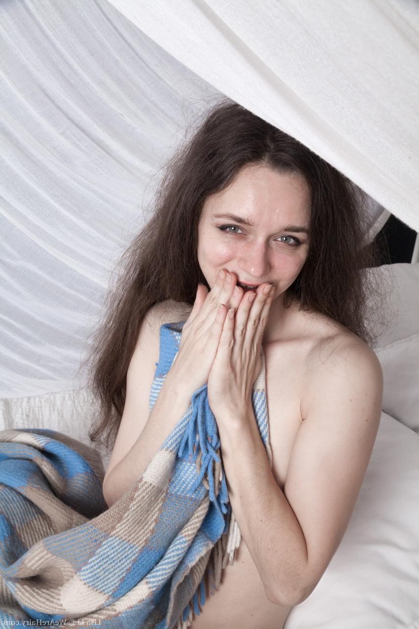 17P Das dünne brünette Babe Lisa Li posiert auf dem Bett und spielt mit ihrem Biber