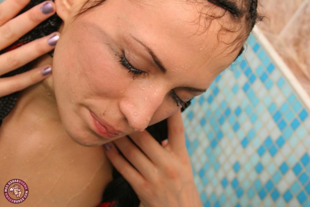 16P La amateur Kristin se da un baño con el pelo oscuro recogido en una cola de caballo trenzada