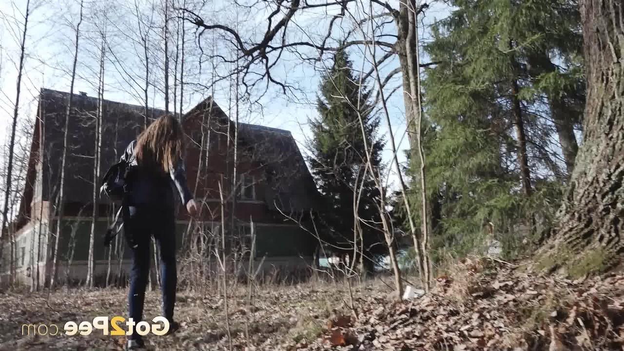 15P A garota branca Vika Lita abaixa a calça jeans para mijar na frente de uma velha árvore