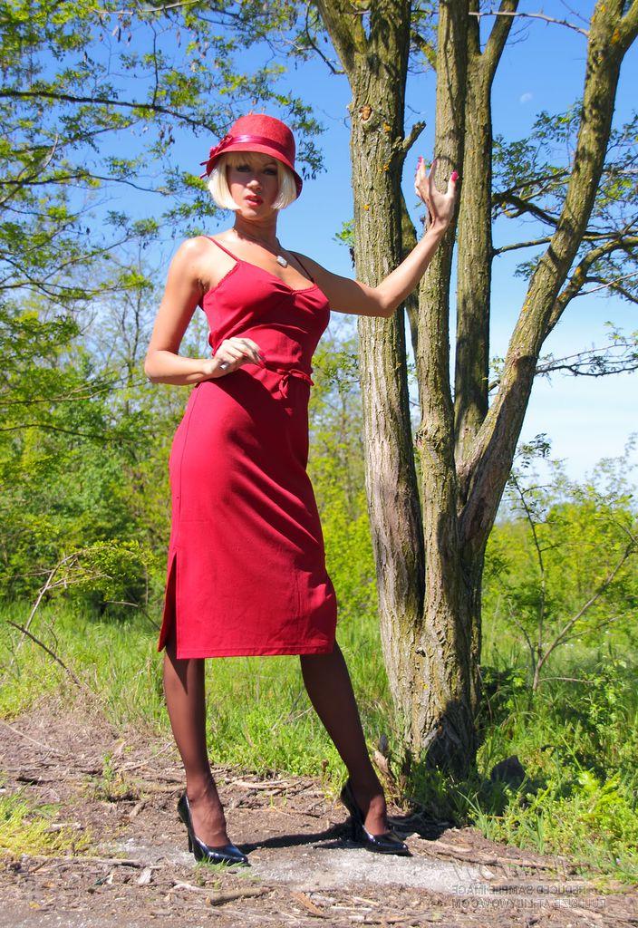 15P Blonde MILF exposes her tits and pussy against a tree in nylons