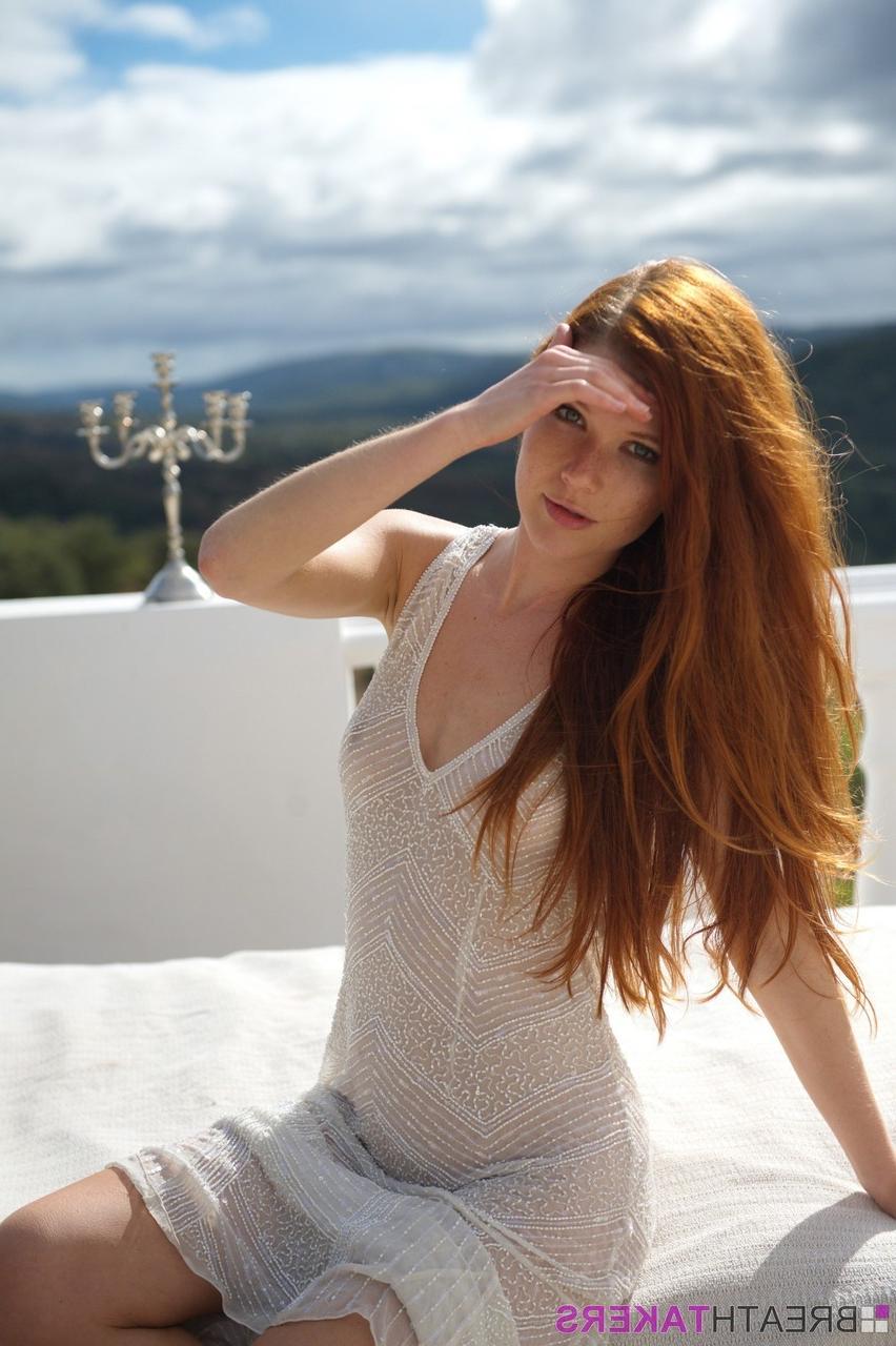 12P La pelirroja pálida Mia Sollis se quita un vestido transparente para posar desnuda en el balcón