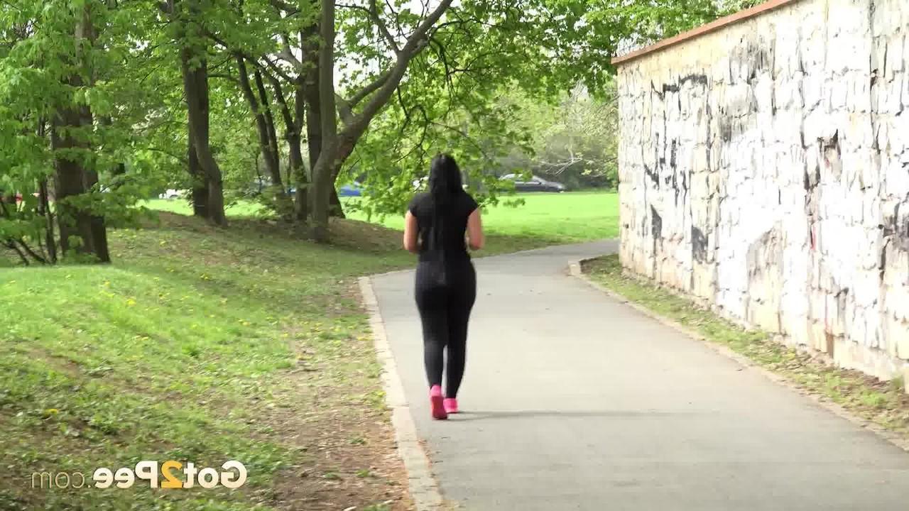 15P A garota morena Lolita Black mija em um caminho pavimentado enquanto sai para passear