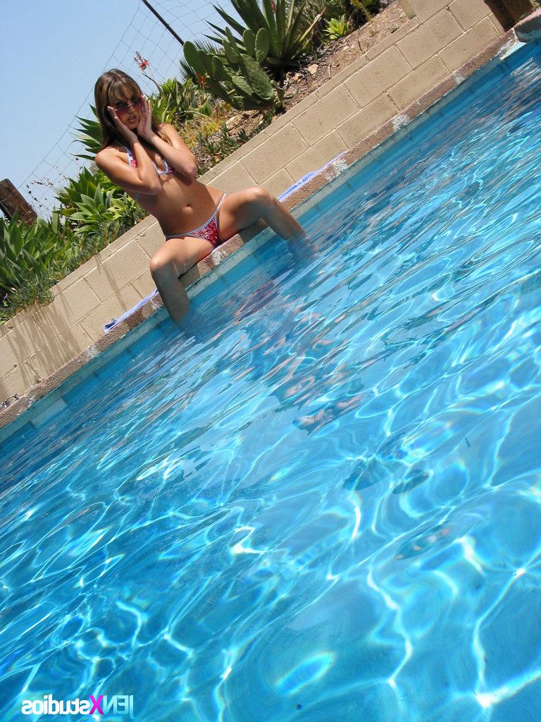 15P Garota sexy fica nua com óculos de sol ao lado de uma piscina