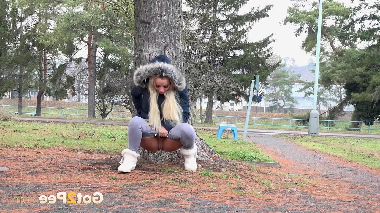 15P Blonde girl Victoria Pure pulls down her leggings to pee against a public tree