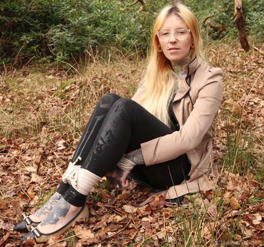 16P Bekleidete Frau wird im Wald geknebelt an Handgelenken und Knöcheln gefesselt