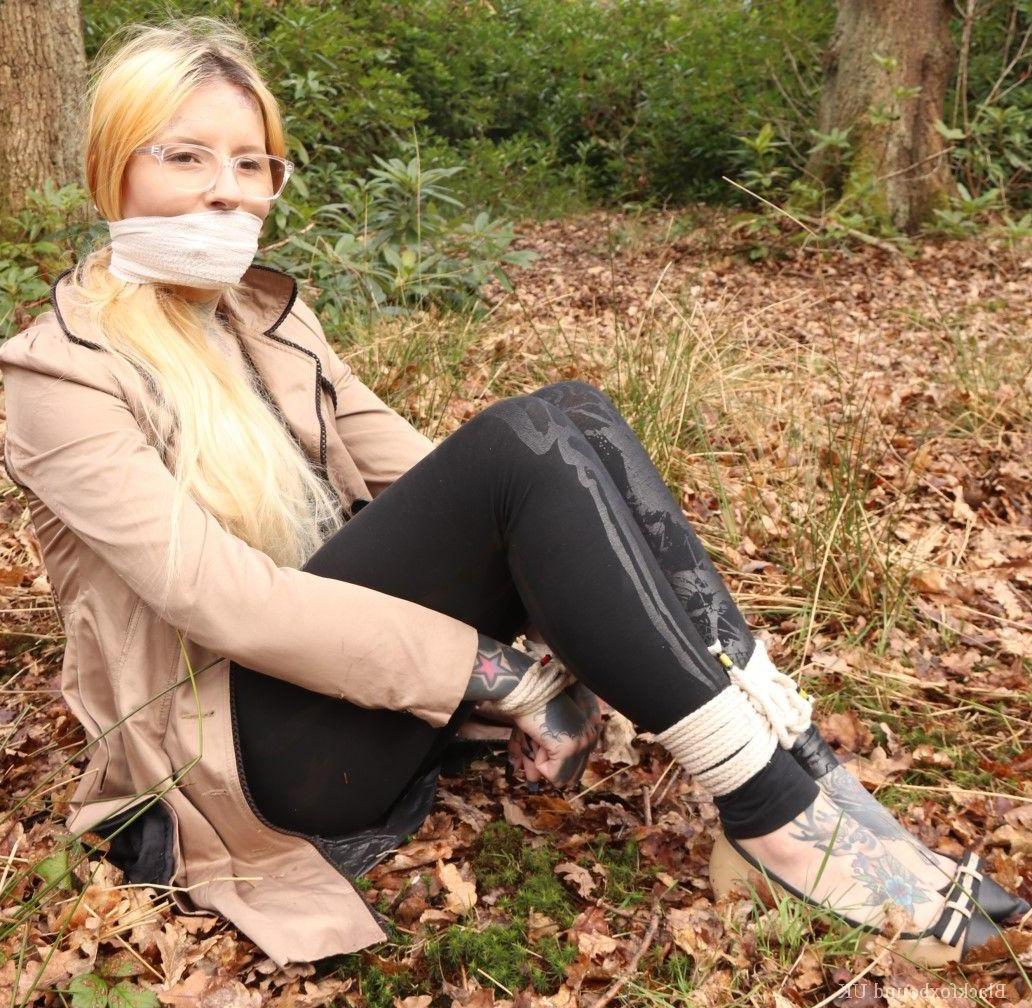 16P Bekleidete Frau wird im Wald geknebelt an Handgelenken und Knöcheln gefesselt